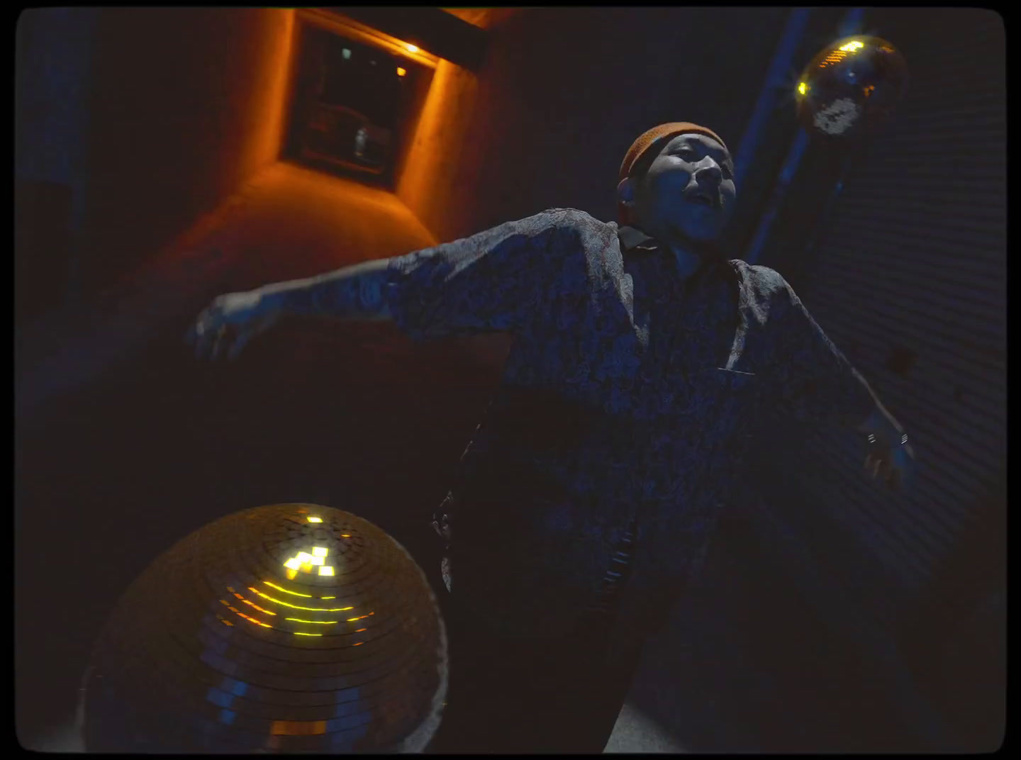 a man standing in front of a disco ball