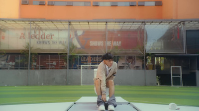 a boy is sitting on a trampoline in front of a building