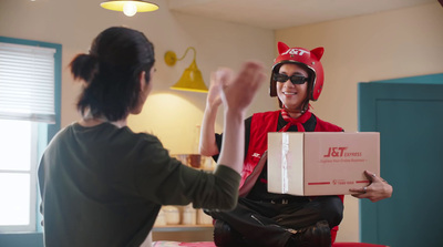 a woman in a cat costume is giving a pizza box to a man in a