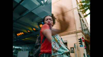 a woman walking down a street next to a tall building