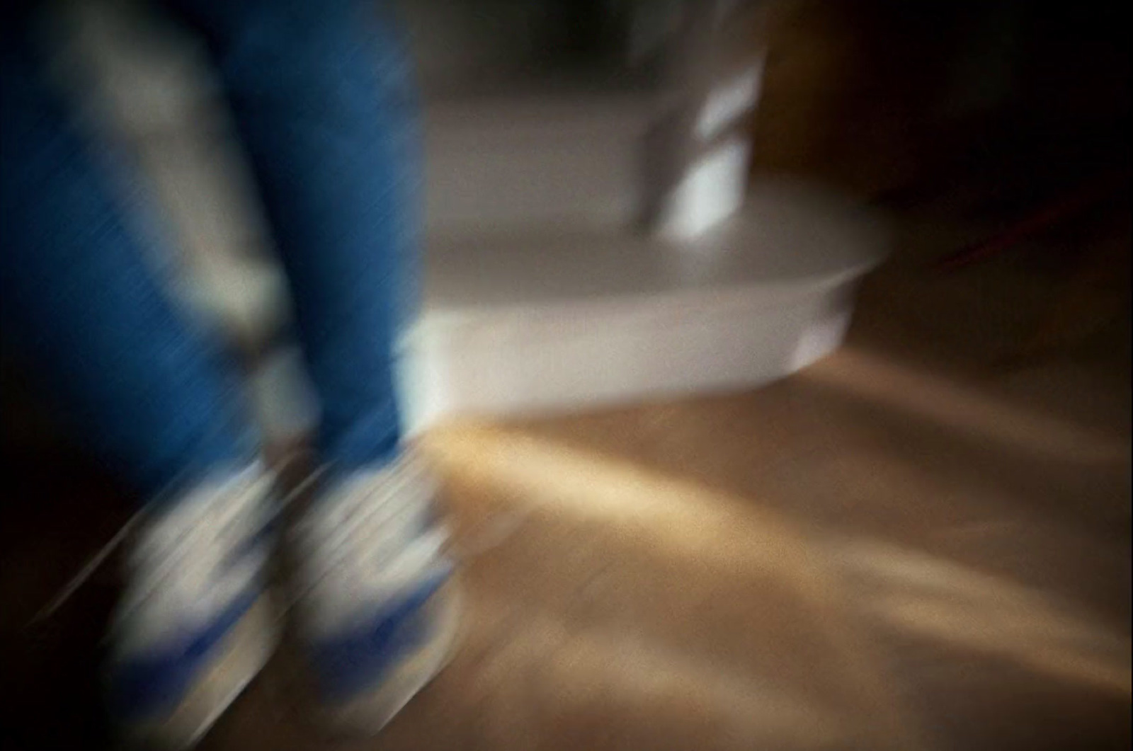 a blurry photo of a person walking on a wooden floor