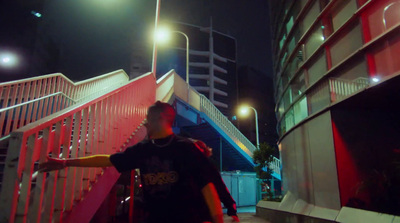 a man standing next to a red staircase at night