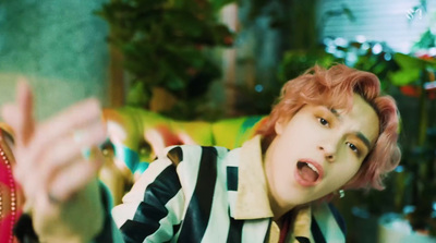 a person with pink hair and a black and white striped shirt