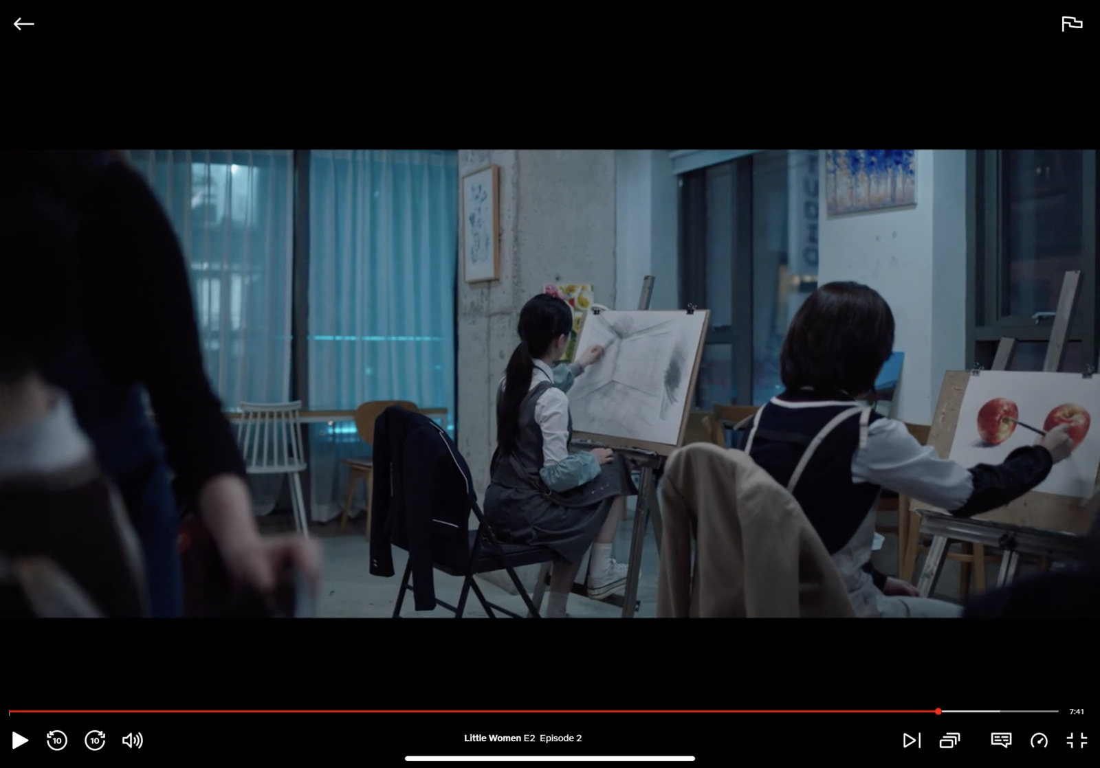 a group of people in a room with easels