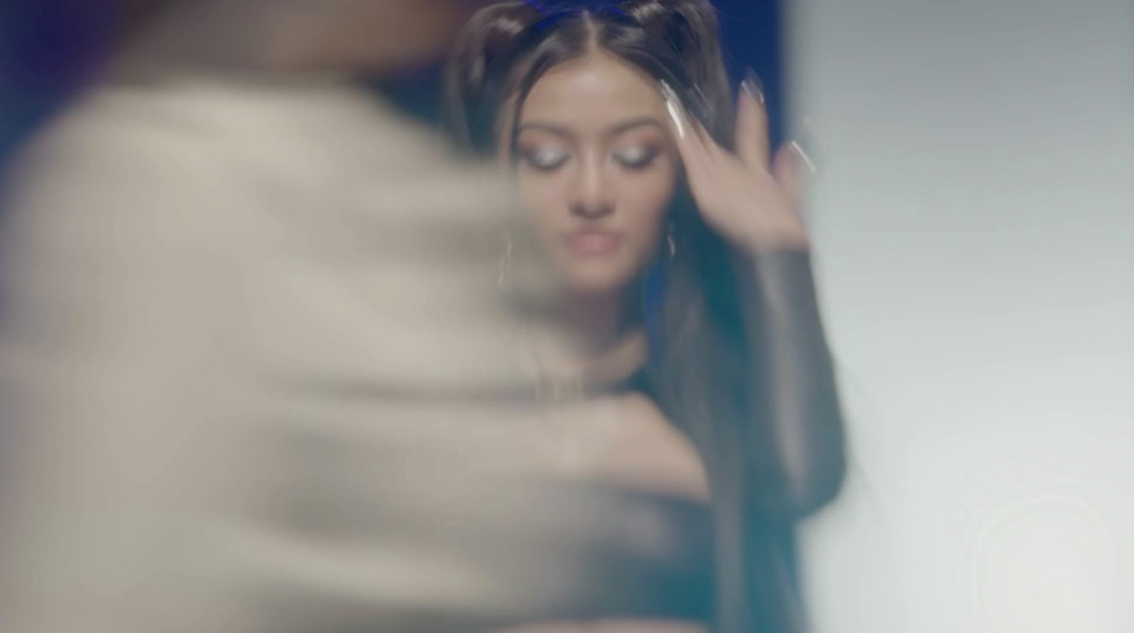 a woman with long hair standing in front of a mirror