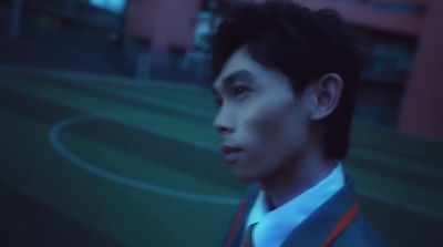 a man in a suit and tie standing in front of a soccer field