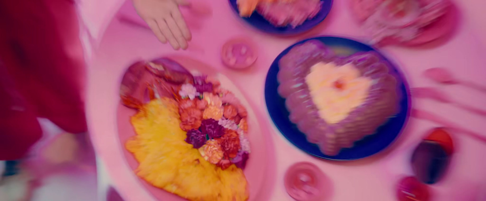 a pink table topped with plates of food