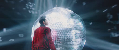 a man standing in front of a mirror ball