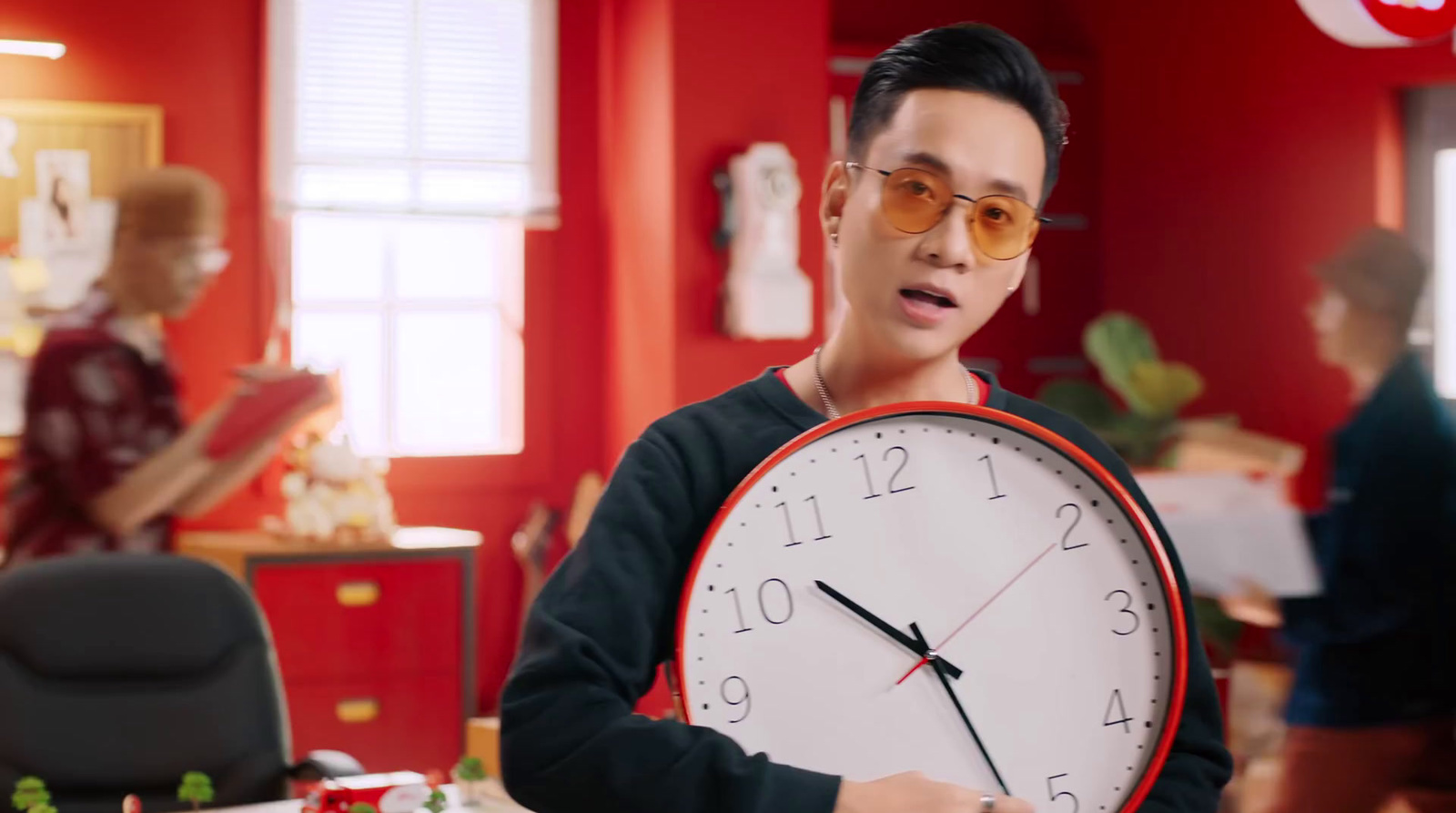 a man holding a large clock in a room