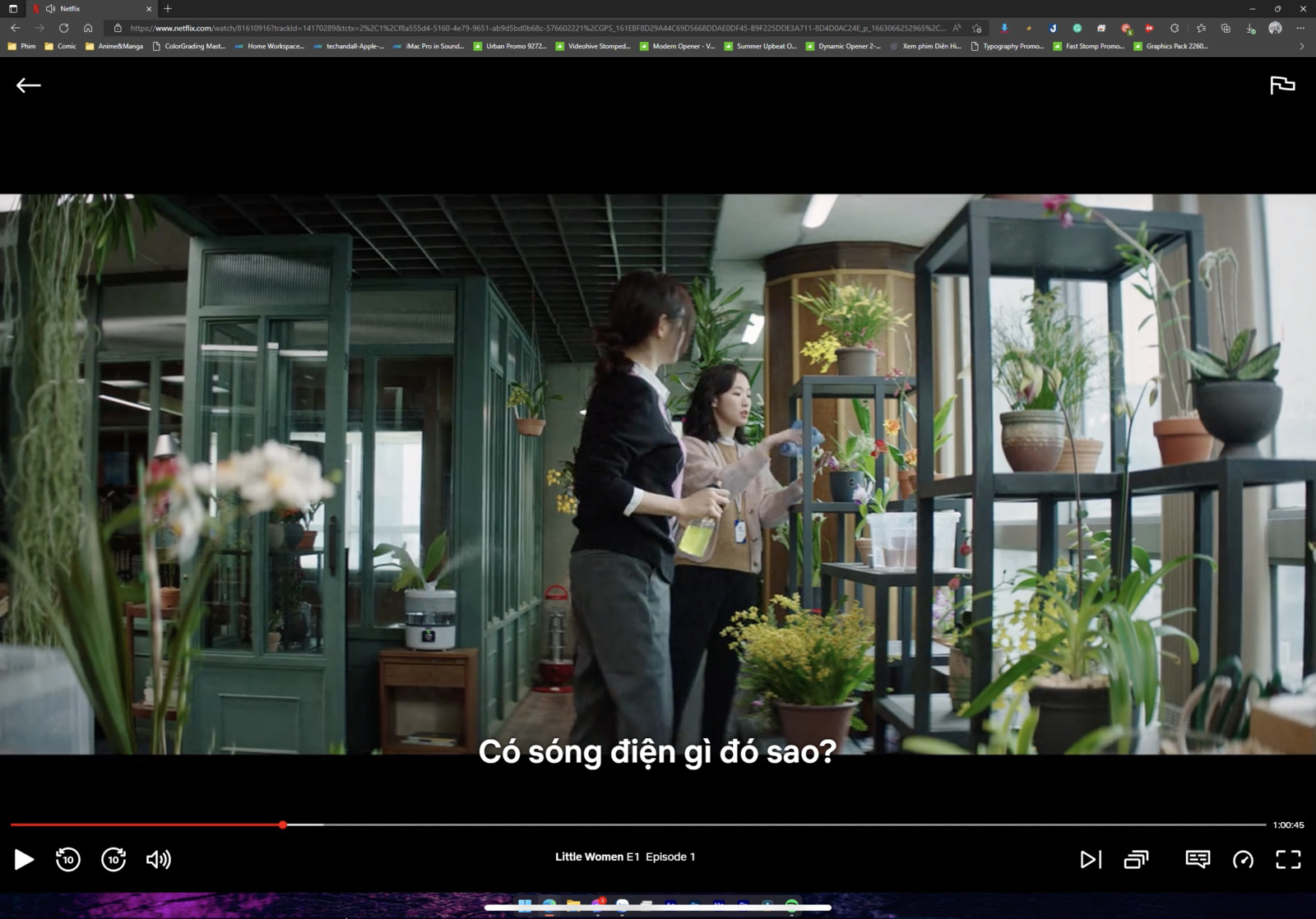 a woman standing in front of a window next to a plant