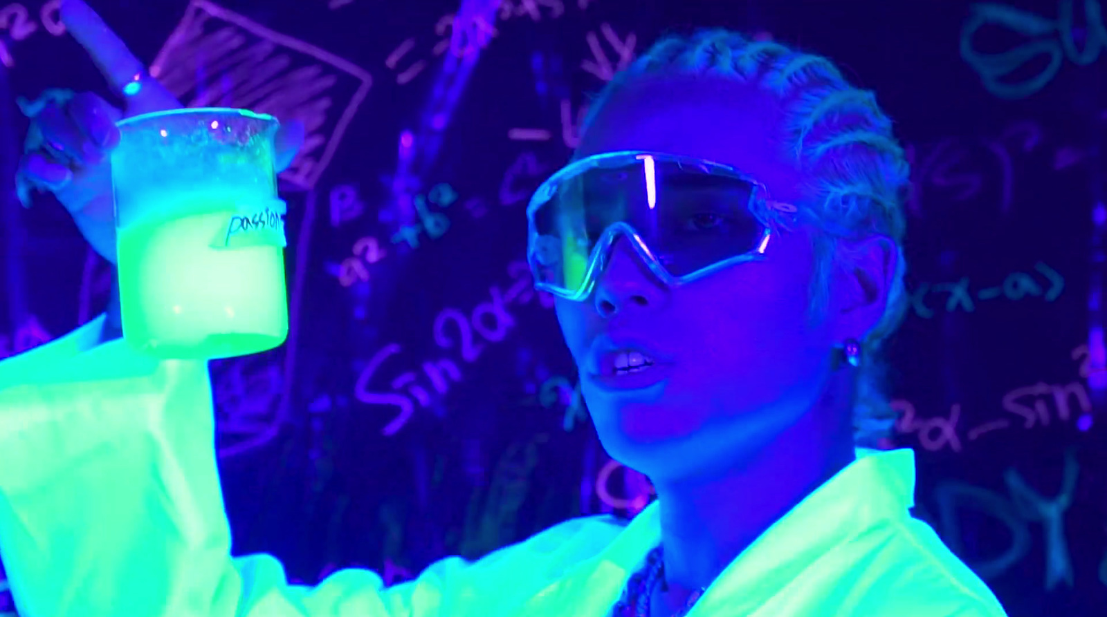 a woman in a lab coat holding a glass with liquid in it