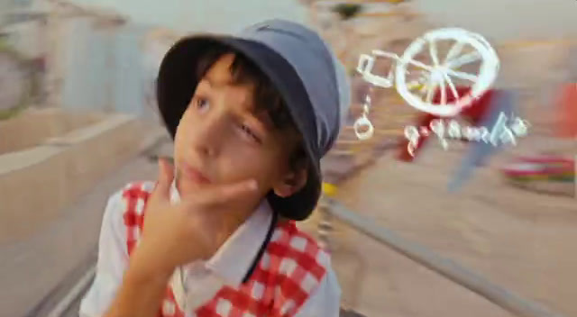 a young man wearing a hat and a red and white checkered shirt