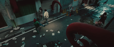 a group of people walking down a street next to a building