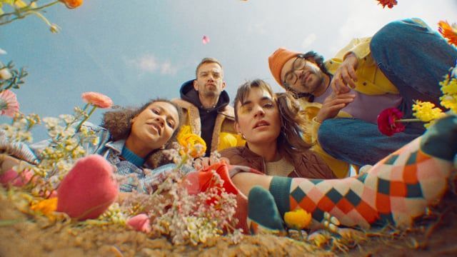 a group of people laying on top of a field of flowers