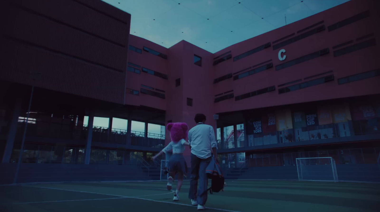 a couple of people walking across a tennis court