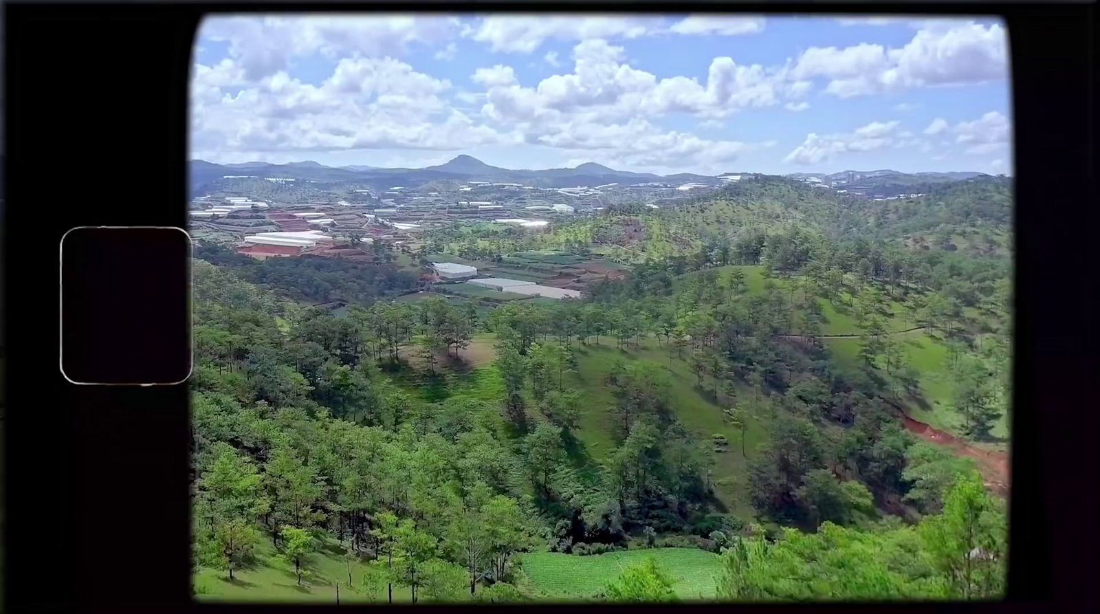 a view from a window of a lush green valley