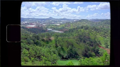 a view from a window of a lush green valley