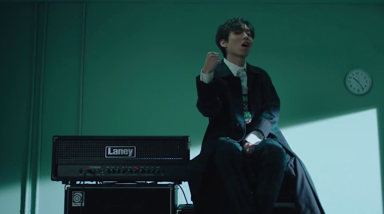 a man sitting on top of a chair next to a amp