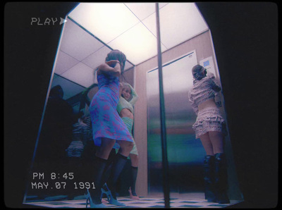 a group of women standing in front of a mirror