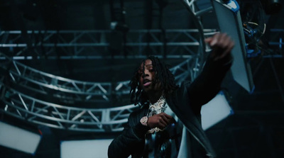 a man with dreadlocks standing in front of a stage