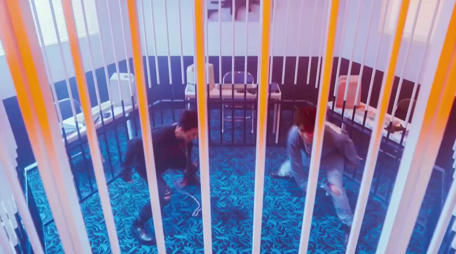 a couple of men standing inside of a jail cell