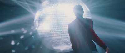 a man standing in front of a disco ball