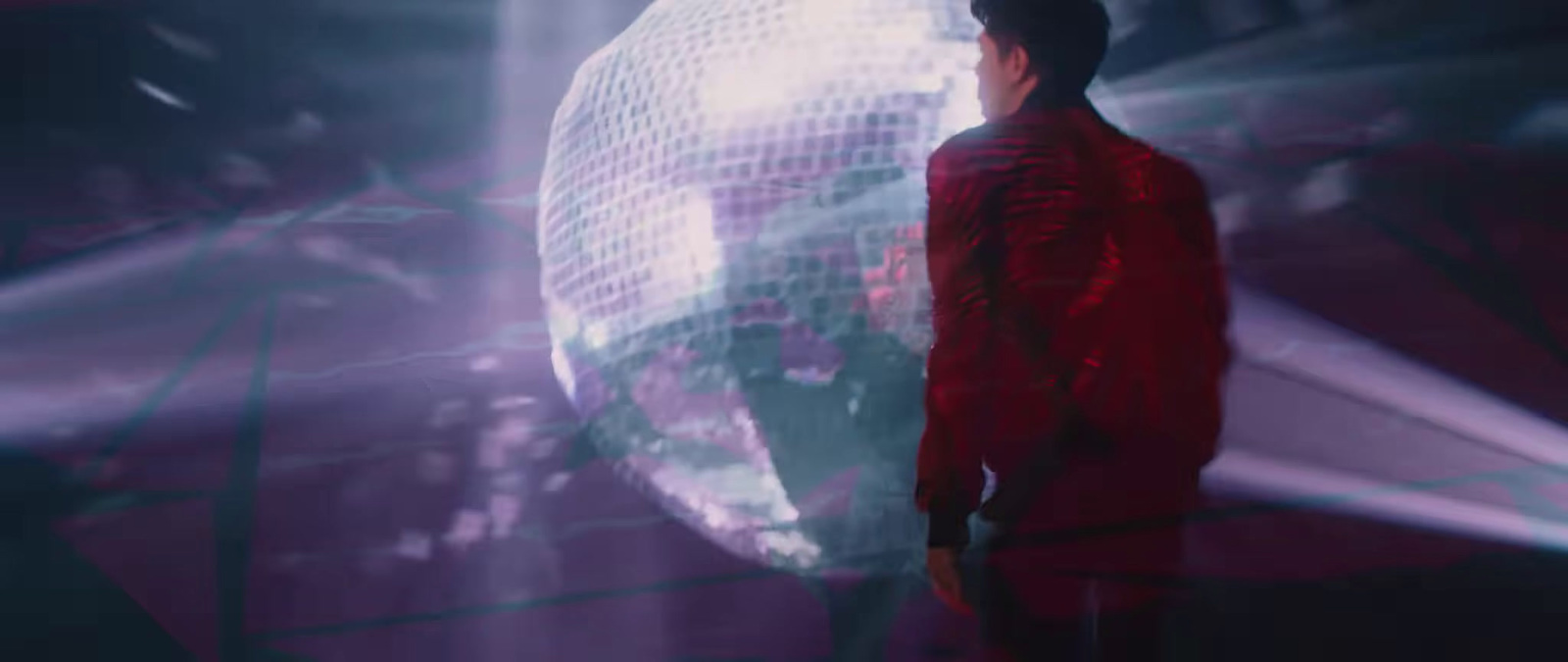 a man standing in front of a disco ball