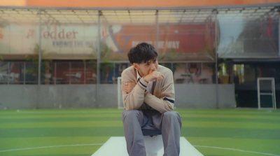 a man sitting on a bench in front of a building