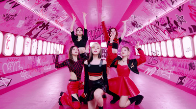 a group of women standing in a pink room