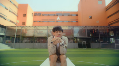 a man sitting on a ledge in front of a building