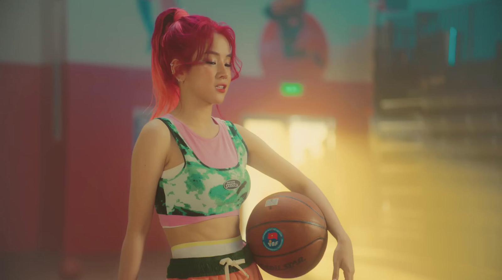 a woman with pink hair holding a basketball