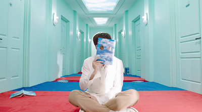 a man sitting on the floor reading a book