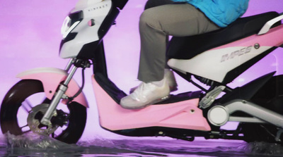 a person riding a pink scooter in the water