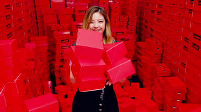 a woman standing in a room full of red boxes