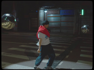 a man walking across a cross walk at night