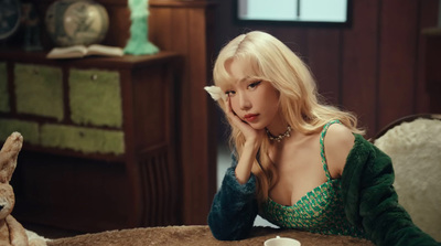 a woman in a green dress sitting at a table