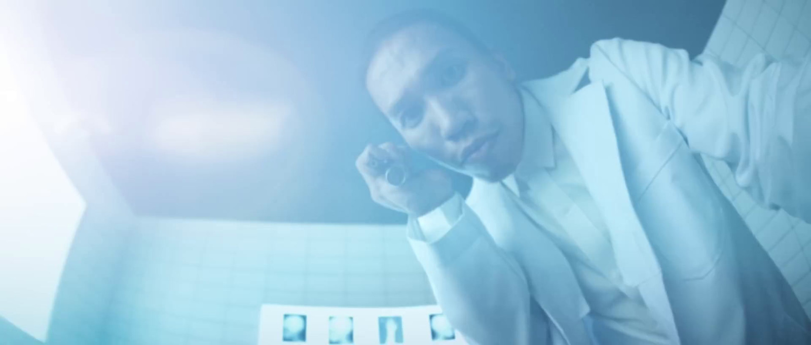 a man in a white suit talking on a cell phone