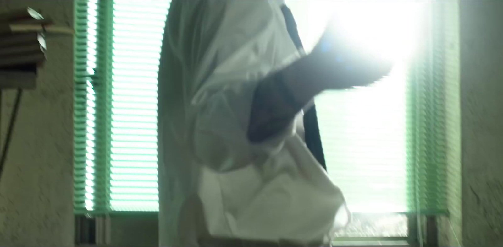 a person in a lab coat standing in front of a window