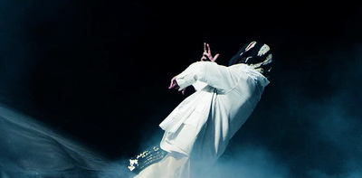 a man dressed in white performing on stage