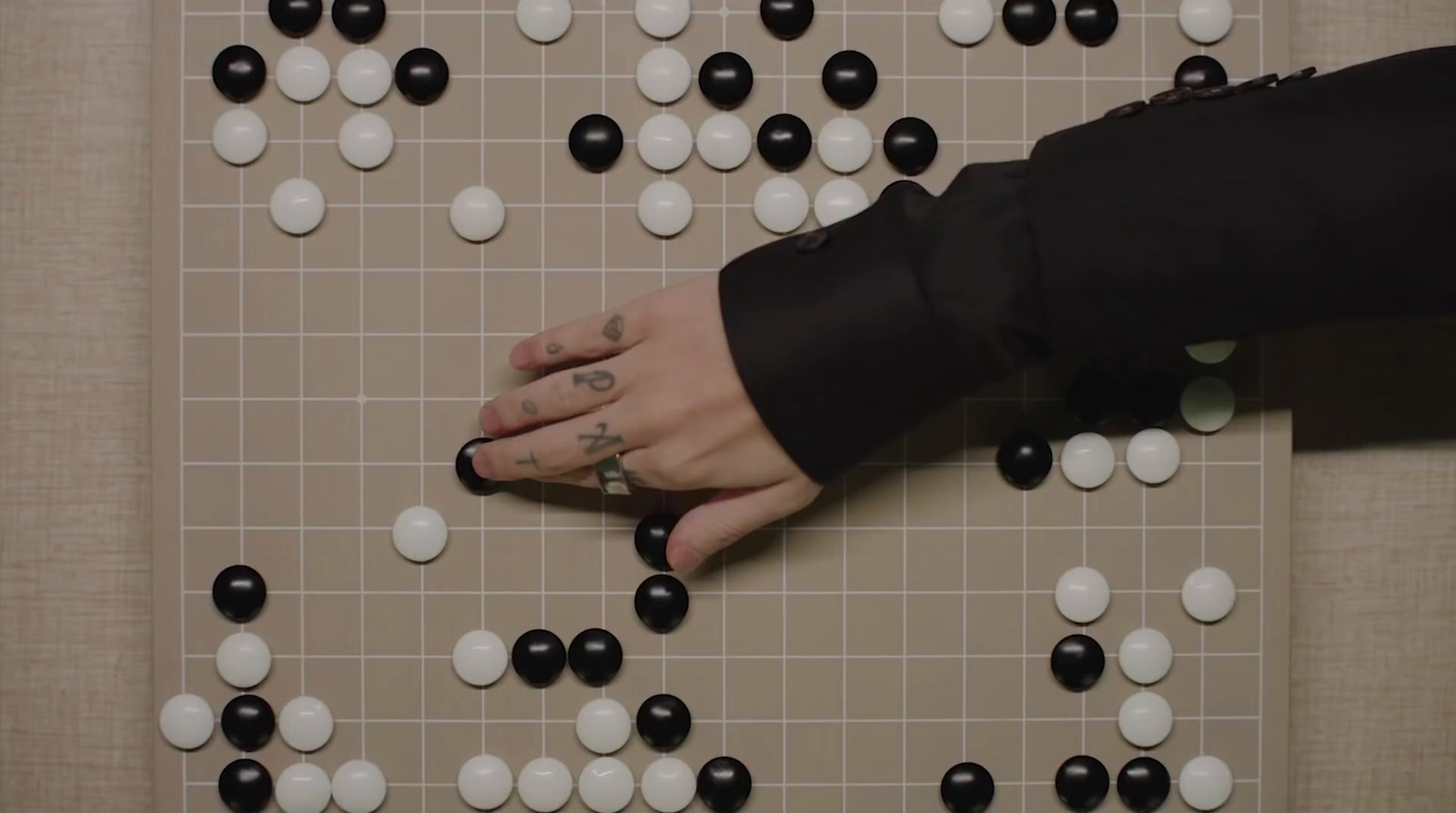 a person's hand on a board with white and black dots