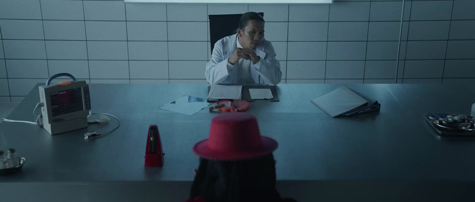 a man sitting at a desk with a red hat