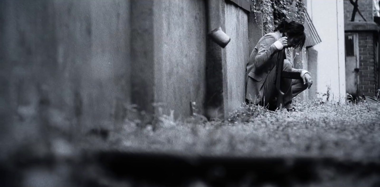 a man sitting on the ground next to a building