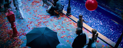 a group of people sitting on a bench under an umbrella