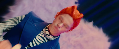 a man with red hair and a blue vest