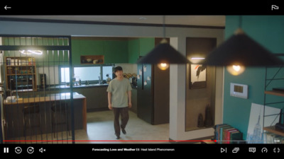 a man standing in a kitchen next to a green wall