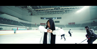 a woman in a white coat standing on a hockey rink