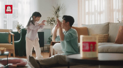 a man and a little girl sitting on a couch in a living room