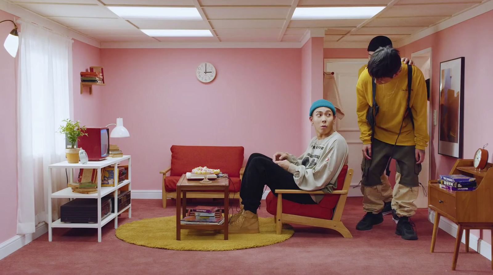 a man and a woman standing in a pink room