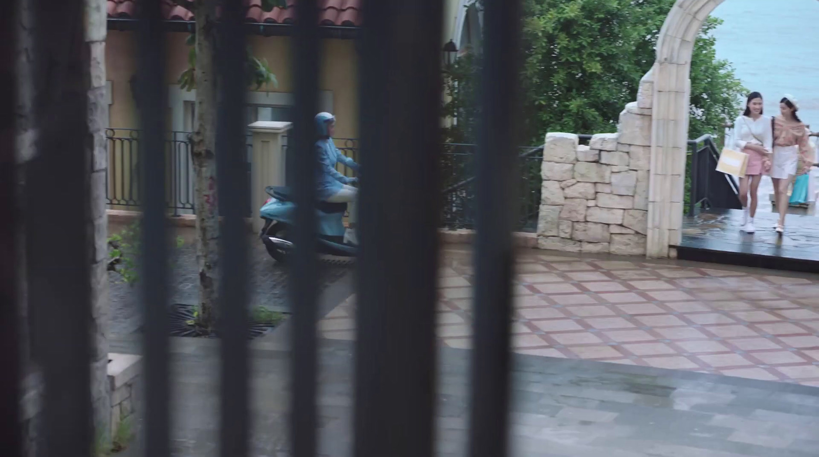 a man riding a scooter through a gate