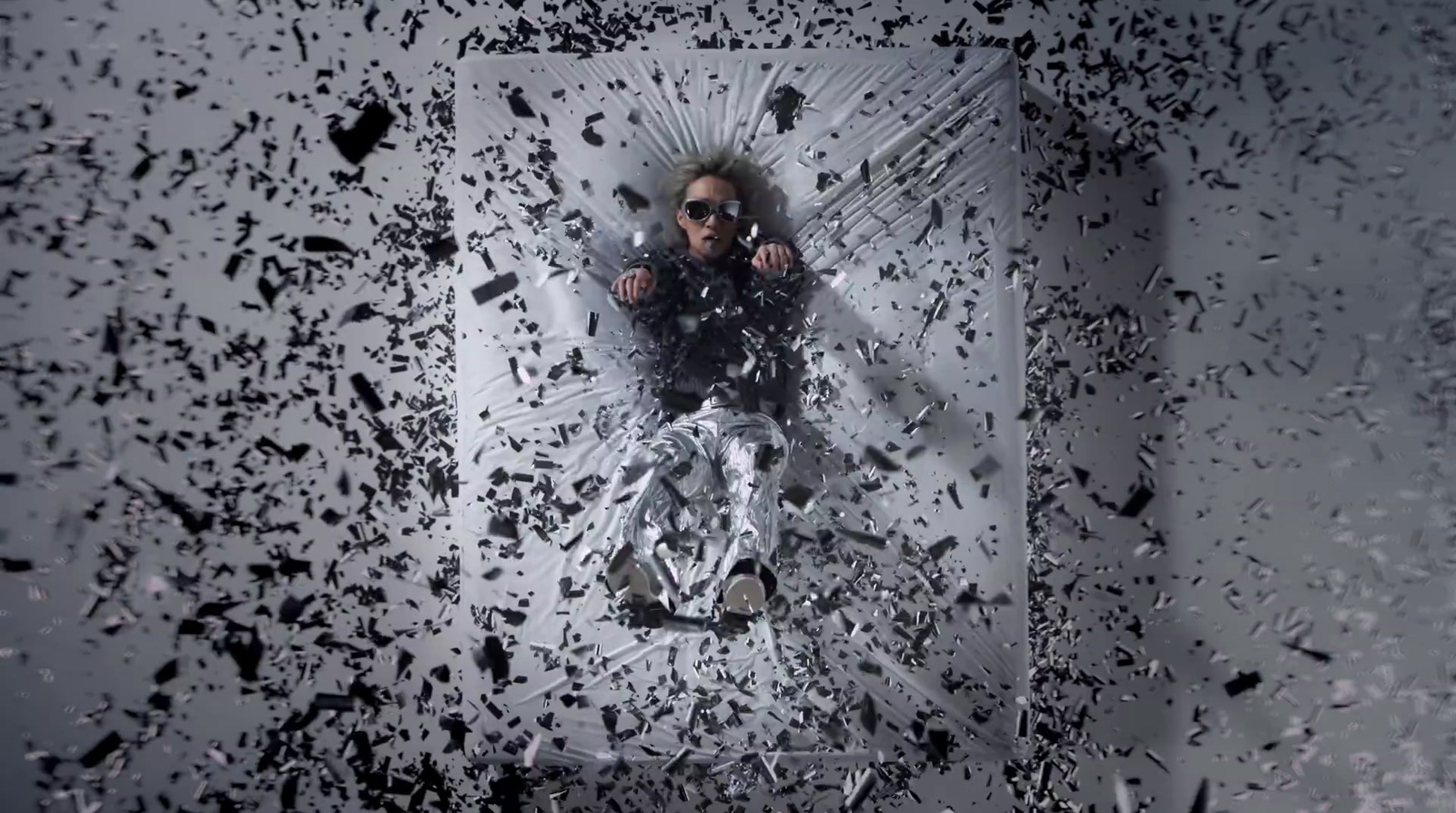 a man laying on top of a floor covered in black and white paint